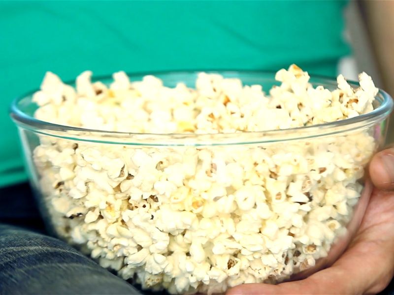 osoba jede kokice iz vatrostalne činije